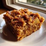 Close-up of a square slice of apple cinnamon baked oatmeal with a rich, brown sugar crumble topping.