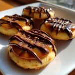Four finished caramel ritz cracker christmas cookies topped with gooey caramel and drizzled with dark chocolate.