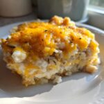 A close-up serving of creamy chicken and wild rice casserole topped with melted cheddar cheese.