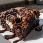 A rich, fudgy square of hot chocolate brownies featuring melted marshmallow filling and a dark chocolate syrup drizzle.