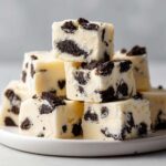 A tempting stack of white chocolate Oreo fudge squares loaded with crushed chocolate sandwich cookies.
