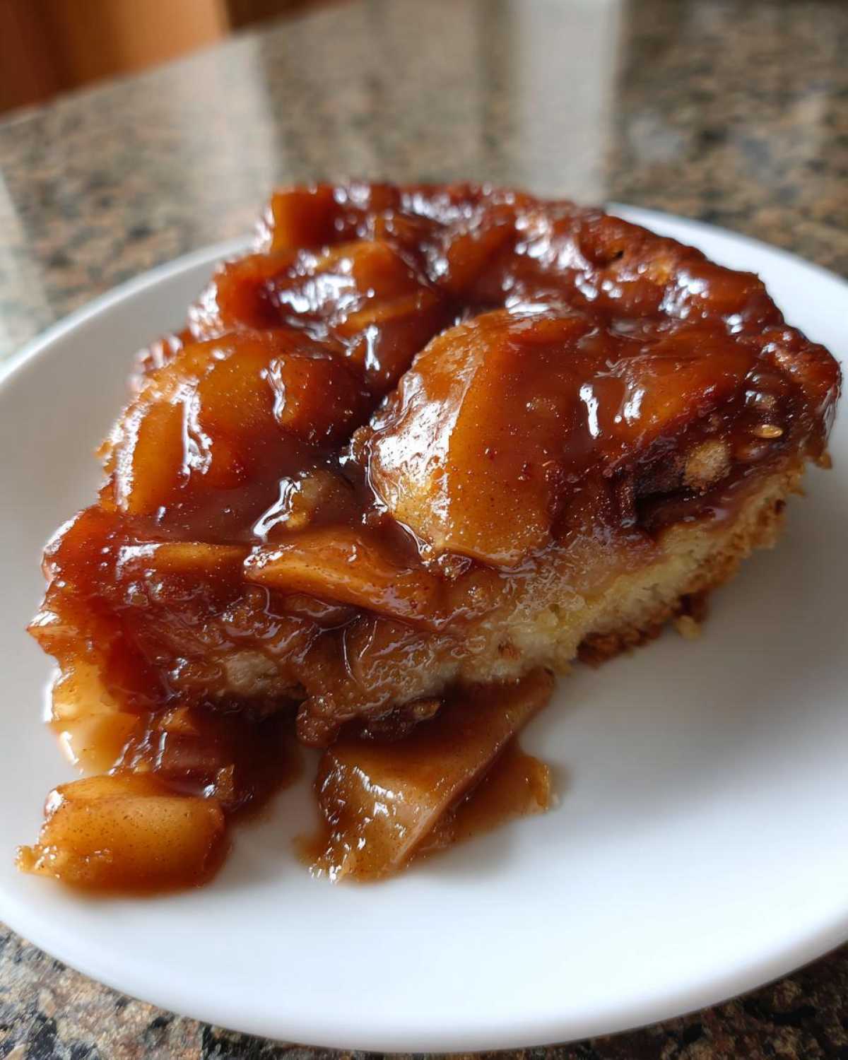 Close-up of a slice of cake or pastry generously topped with glossy, caramelized apple pie filling recipe.