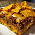 Close-up of a hearty slice of Dorito Casserole featuring seasoned ground beef, melted cheese, and crunchy Doritos on top.