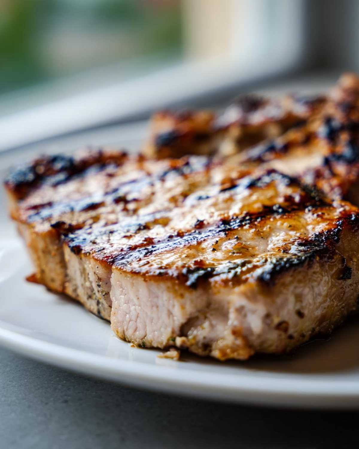 Close-up of perfectly grilled pork chops showing char marks, prepared using the marinade for pork chops recipe.
