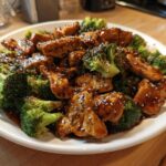 Close-up of glazed chicken and broccoli stir-fry, featuring sesame seeds, a perfect chicken and broccoli dish.