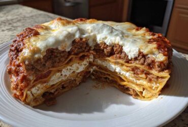 A generous, thick slice of Lasagna with Cottage Cheese, showing multiple layers of pasta, meat sauce, and white cottage cheese filling.