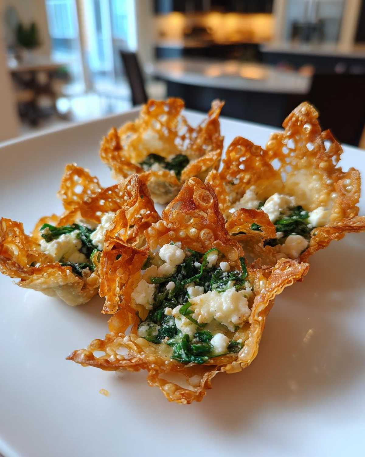 Close-up of crispy wonton cups filled with Mediterranean spinach and feta cheese mixture.
