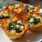 Close-up of golden, crispy wonton cups filled with sautéed spinach and crumbled feta cheese, featuring Mediterranean Spinach and Feta Cheese Crisps.
