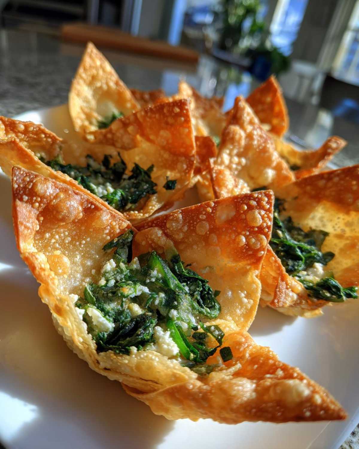 Close-up of golden, crispy wonton cups filled with Mediterranean Spinach and Feta Cheese Crisps mixture.