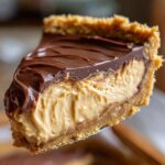 Close-up of a rich slice of no-bake peanut butter pie showing creamy filling and chocolate ganache.