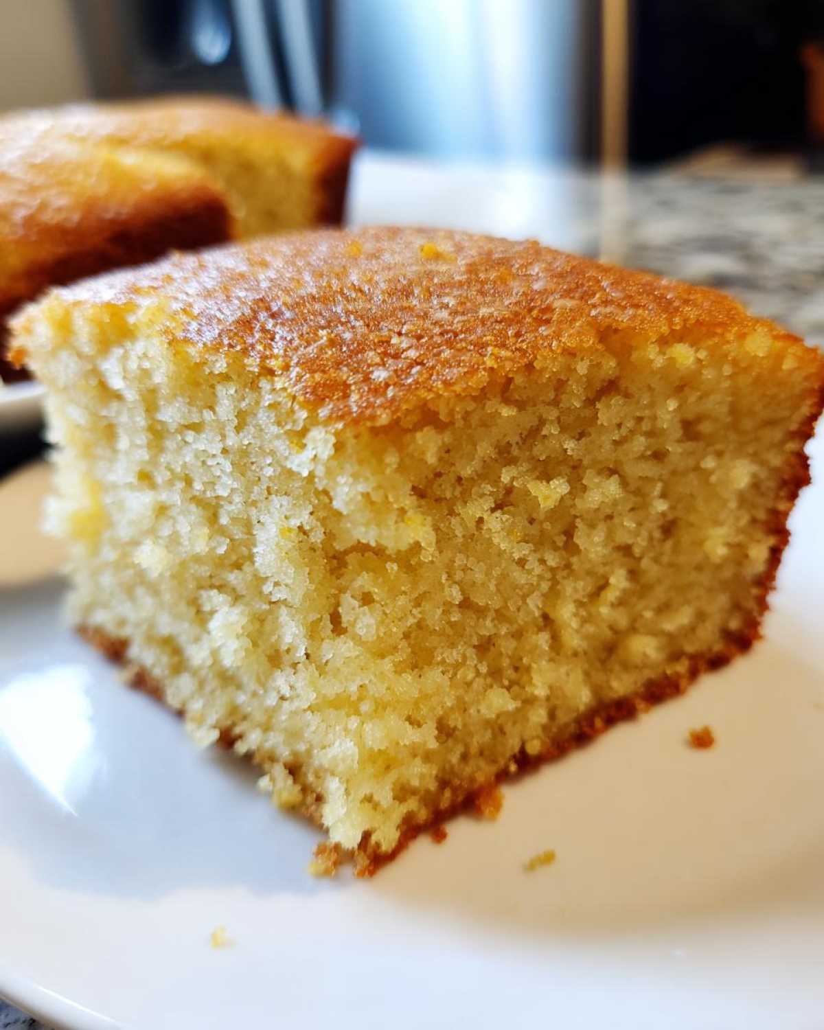A close-up shot highlighting the moist, golden crumb texture of a slice of sourdough cornbread.