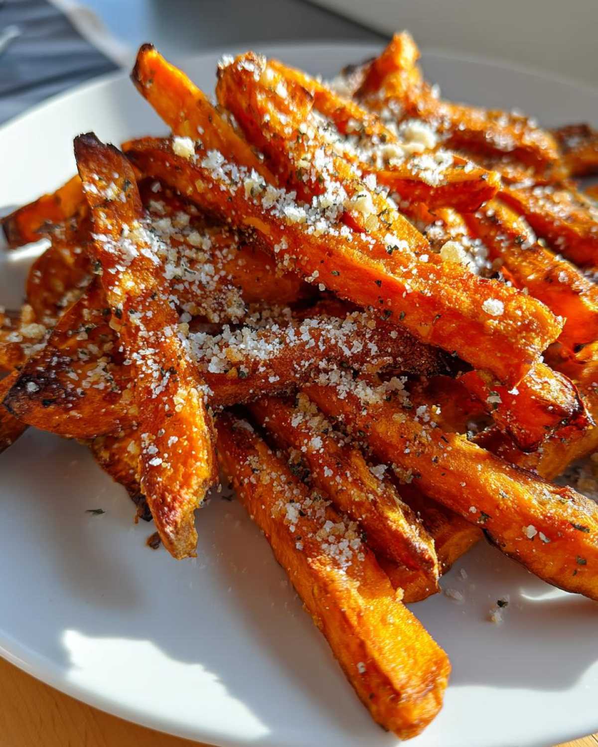 Close-up of crispy Air Fryer Garlic Parmesan Sweet Potato Fries topped with grated cheese.