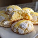 A stack of Gluten-Free Lemon Meltaway Cookies dusted with powdered sugar and drizzled with lemon glaze.