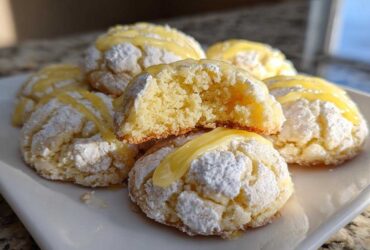 A stack of Gluten-Free Lemon Meltaway Cookies dusted with powdered sugar and drizzled with lemon glaze.