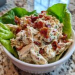 Creamy Keto Bacon Ranch Chicken Salad filling served in crisp lettuce cups, topped with crumbled bacon.