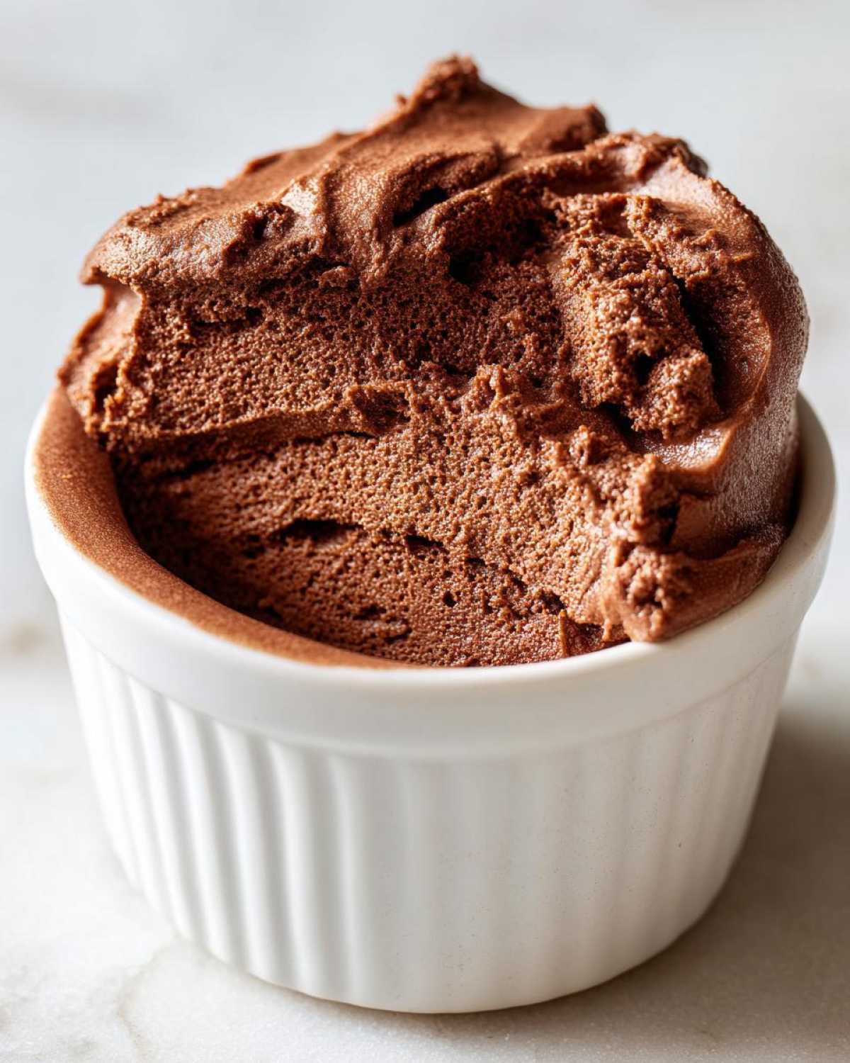 Close-up of rich, airy Keto Creamy Chocolate Cheesecake Mousse served in a white ramekin.