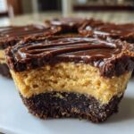 Close-up of a No-Bake Chocolate Peanut Butter Cheesecake Cup with a bite taken out, showing the layers.