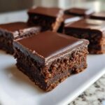 A close-up of a rich, fudgy square of No-Bake Espresso Chocolate Fudge Squares topped with a smooth chocolate glaze.