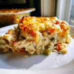 A close-up slice of Cheesy Chicken and Rice Casserole Easy Bake with golden melted cheese topping.