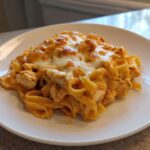 A serving of Creamy Cajun Chicken Alfredo Bake with melted, slightly browned cheese on top.