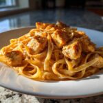 Close-up of fettuccine pasta coated in a creamy sauce, topped with seasoned, seared chicken pieces for Creamy Cajun Chicken Pasta with Bold Flavor.