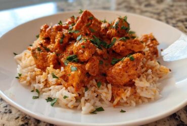A close-up of Creamy Cajun Chicken Skillet with Rice served on a white plate, garnished with fresh parsley.