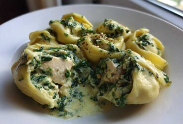 Close-up of tortellini filled with chicken and covered in a rich Creamy Chicken Tortellini with Spinach Sauce.