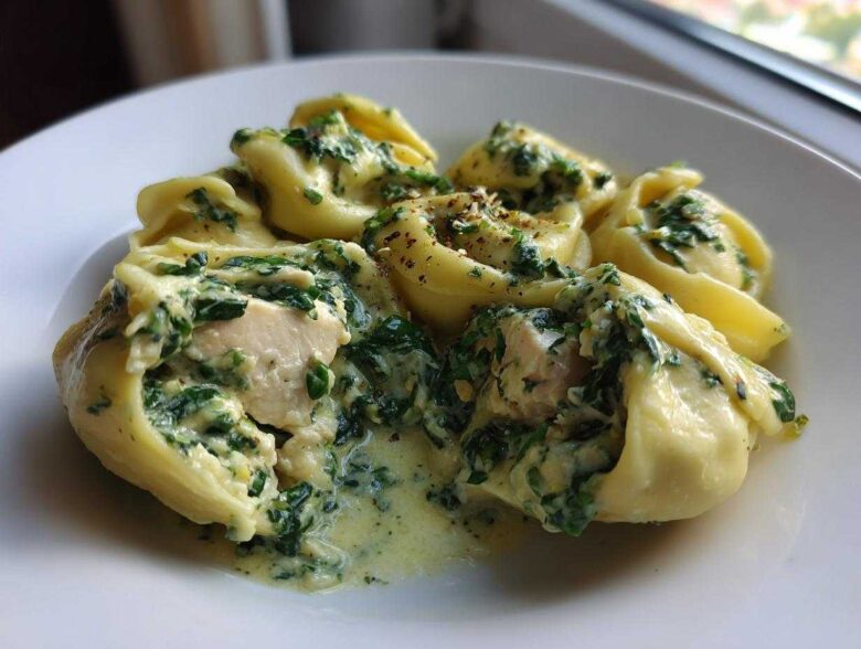 Close-up of tortellini filled with chicken and covered in a rich Creamy Chicken Tortellini with Spinach Sauce.