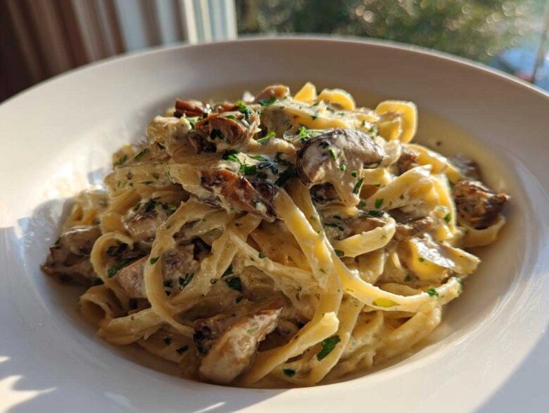 A close-up of fettuccine pasta coated in a rich, creamy mushroom sauce and garnished with fresh parsley, showcasing the Creamy Mushroom Pasta with Parmesan Sauce.