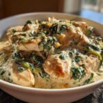 Close-up of tender chicken pieces smothered in a rich, creamy sauce with wilted spinach, part of the Creamy Spinach Chicken Skillet with Parmesan.