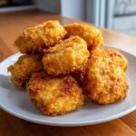 A pile of golden brown, extra crunchy homemade Crispy Chicken Nuggets Homemade Extra Crunchy on a white plate.