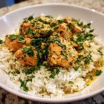 Close-up of Garlic Butter Chicken and Rice One Pot Dinner topped with fresh parsley.