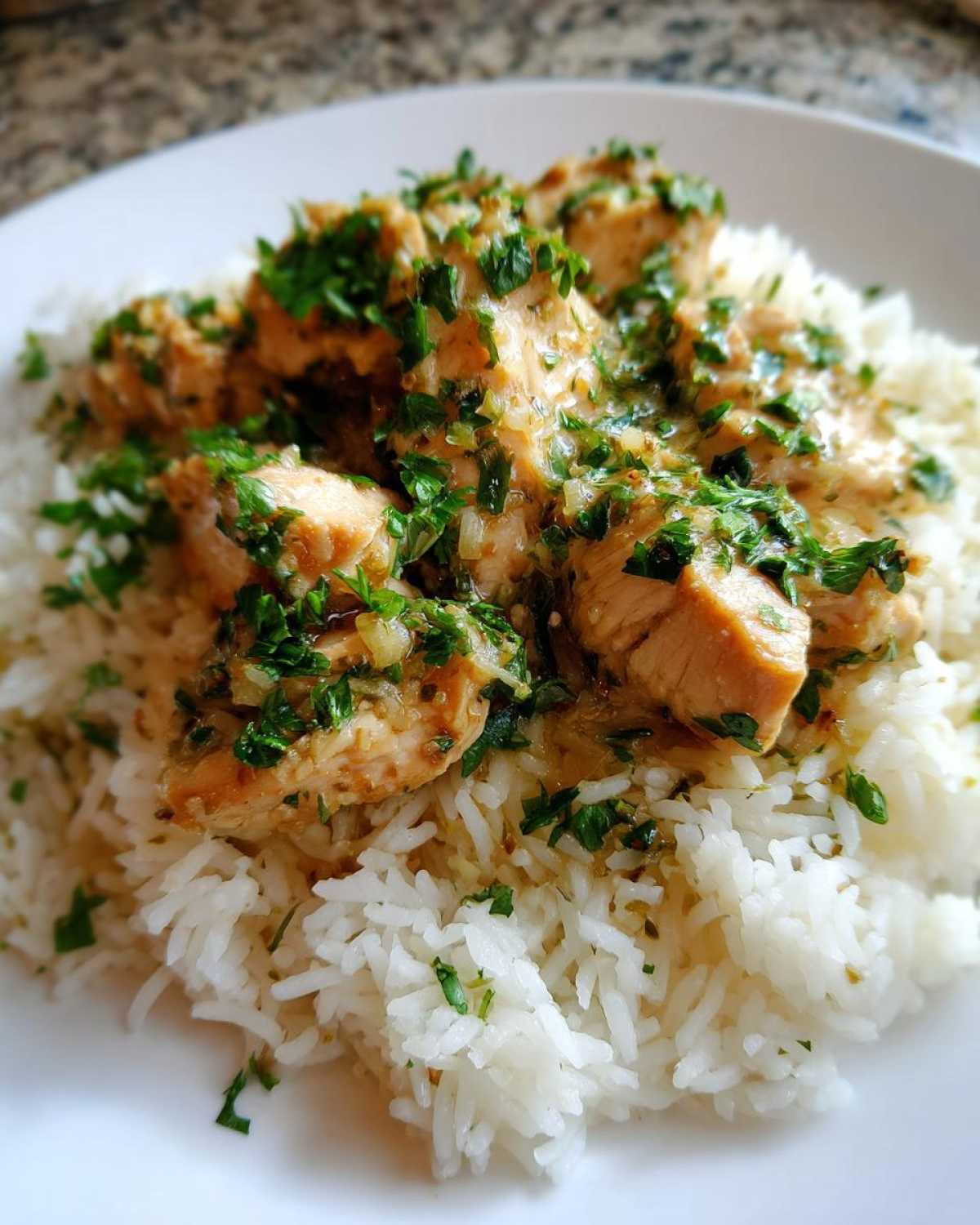 Close-up of tender chicken pieces in a rich sauce served over fluffy white rice, garnished with fresh parsley for the Garlic Butter Chicken and Rice One Pot Dinner.