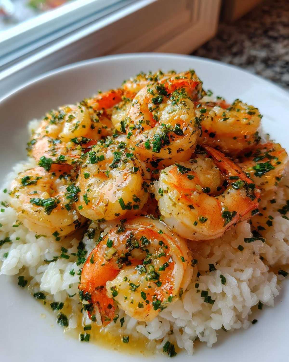 Close-up of a Garlic Butter Shrimp Rice Bowl featuring plump shrimp coated in garlic butter and fresh herbs over white rice.