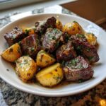 Close-up of juicy steak bites and roasted potatoes coated in garlic butter sauce, part of a Garlic Butter Steak and Potatoes Skillet.
