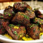 Close-up of perfectly seared Garlic Butter Steak Bites coated in garlic and parsley sauce.