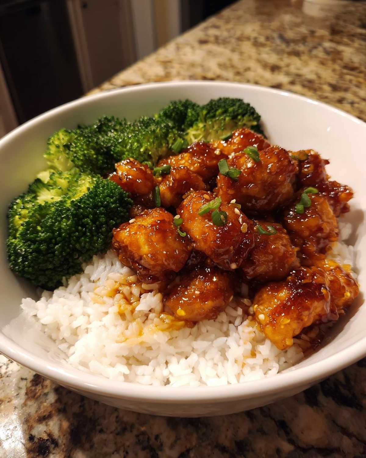 Close-up of a Honey Garlic Chicken Bowl with rice, sticky glazed chicken pieces, and steamed broccoli.