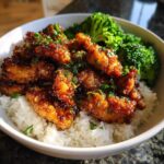Close-up of a Honey Garlic Chicken Bowl featuring glazed chicken pieces over white rice and steamed broccoli florets.