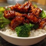 Close-up of a Honey Soy Chicken Bowl Quick Dinner Idea featuring glazed chicken pieces over white rice and bright green broccoli florets.