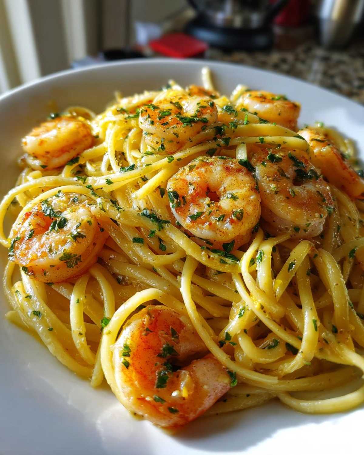 A close-up of a bowl of Lemon Butter Shrimp Pasta, featuring linguine coated in buttery sauce and topped with seasoned shrimp and parsley.