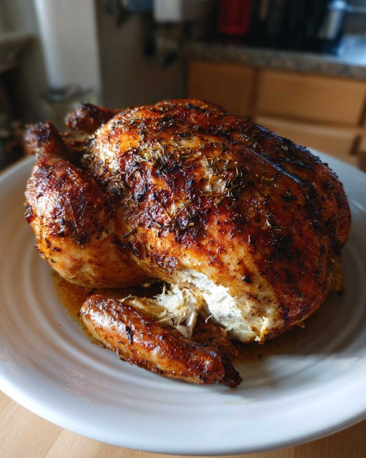 A whole, perfectly roasted Lemon Herb Roasted Chicken with crispy, browned skin resting on a white plate.