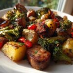 Close-up of a serving of One Pan Sausage and Potatoes Roasted Dinner with broccoli and red peppers.