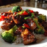 Close-up of Sticky Teriyaki Chicken Stir Fry Quick Meal served over white rice with bright green broccoli and red peppers.
